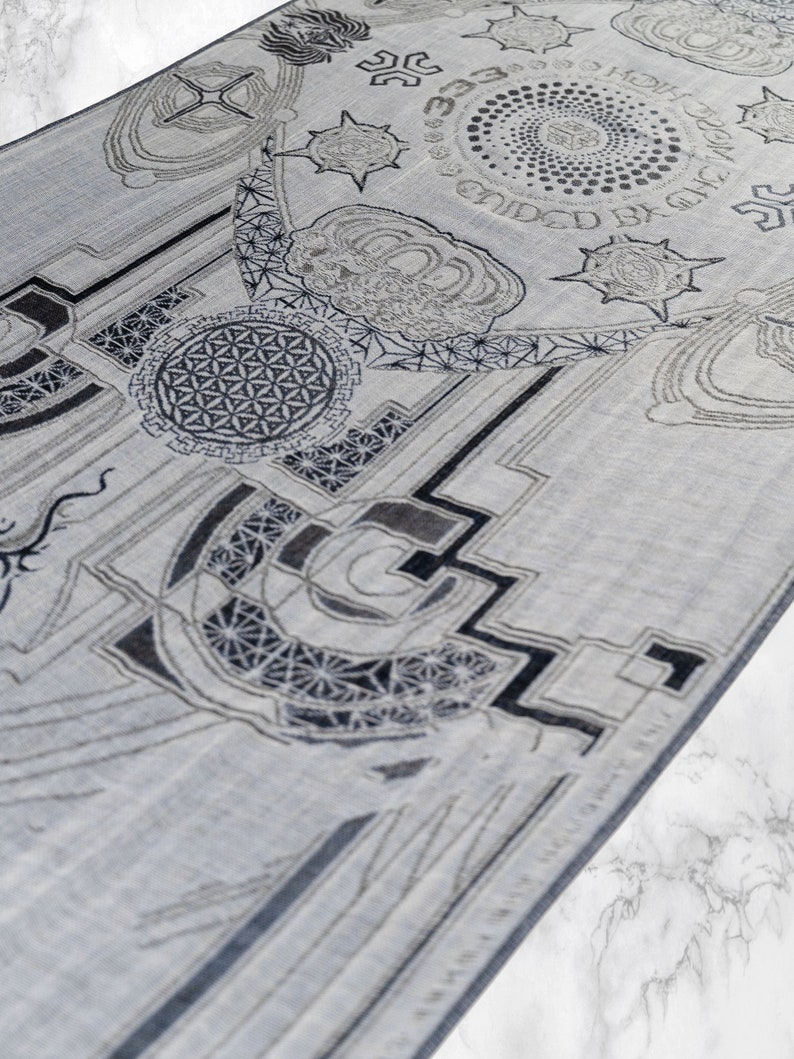 May include: A gray and white patterned rug with geometric designs and the text "Guided by the Light" in a circle.