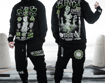 May include: A black hoodie with a green and white graphic print featuring the text "Reconnect with your Source" and "Evolve Your Trinity". The hoodie is paired with black sweatpants with a similar graphic print on the left leg.