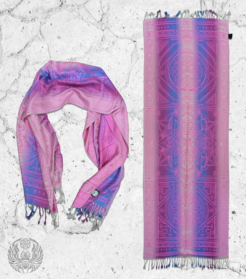 May include: A pink and blue patterned scarf with a geometric design. The scarf is folded and laid out on a white textured surface. The text "TRIZE RISE A STAND" is printed on the scarf.
