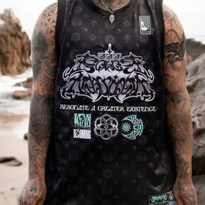 May include: Black mesh jersey with a large, stylized graphic in silver and white. The jersey features the text "Resonate a Greater Existence" and other graphics in teal and silver. The jersey has a small tag at the bottom with additional text.