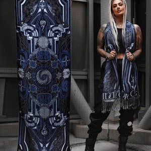May include: A blue and black patterned scarf with fringe. The scarf features a geometric design with a circular mandala in the centre. The text "Divine Guidance" is printed on the bottom of the scarf.