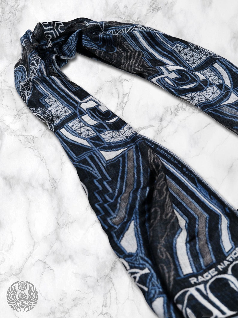 May include: A blue and white patterned scarf with geometric designs. The scarf has a fringe edge and features the text "Rage Nation" in white.