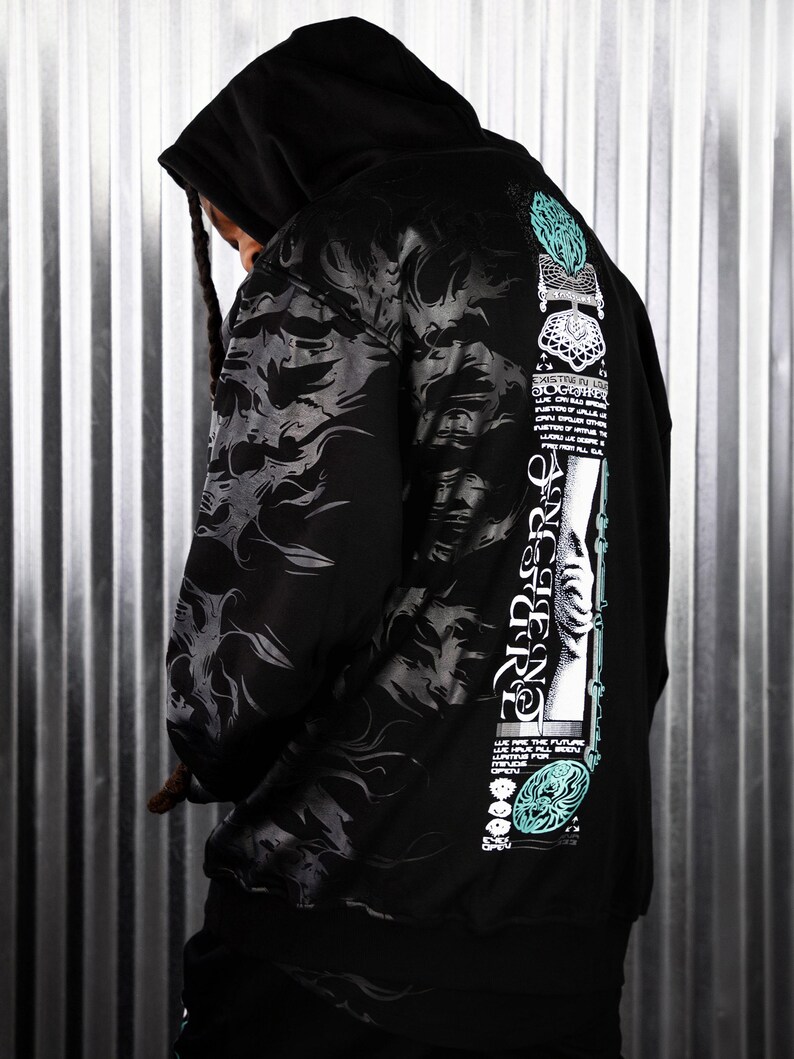 May include: Black hooded sweatshirt with a graphic print on the back. The print features a hand reaching up with the text "EXISTRE IN LOVE TOGETHER" and other text and designs.