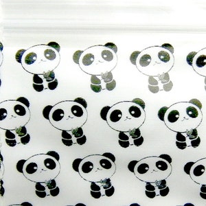 May include: A white plastic bag with a repeating pattern of black and white panda bears holding bamboo. The pandas are cartoon-like and have a simple design.