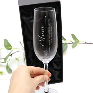 May include: A clear glass champagne flute with an engraved message that reads "To Mum - Thanks for everything you do. From Samantha". The flute is in a black box with a satin lining.