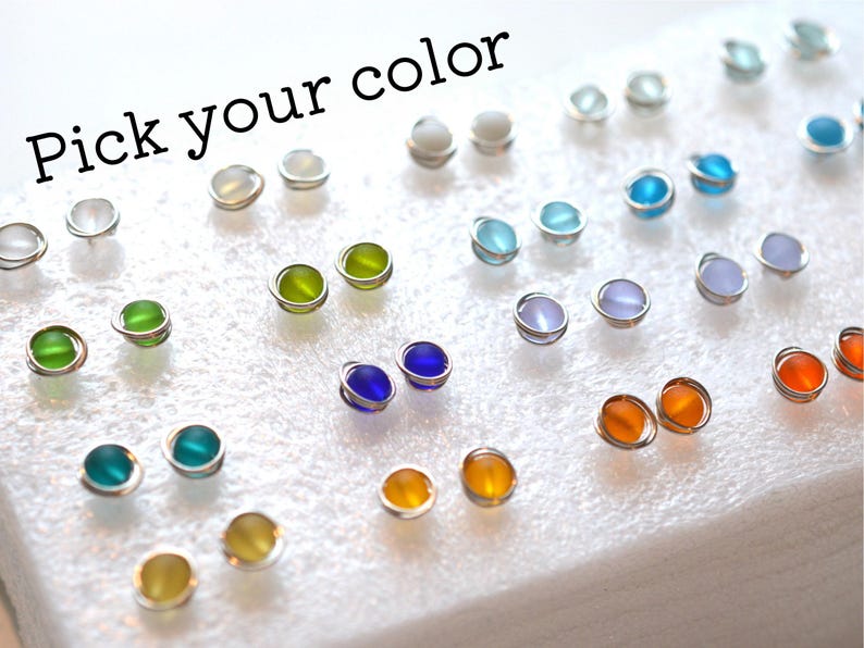 May include: A variety of colors of glass beads on a white foam surface. The text "Pick your color" is at the top of the image.