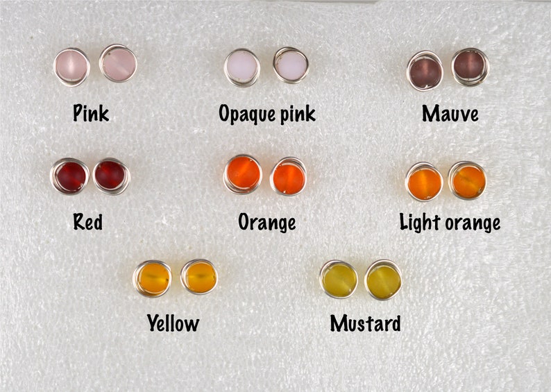 May include: A set of 10 pairs of earrings with different colored glass beads. The colors include pink, opaque pink, mauve, red, orange, light orange, yellow, and mustard.