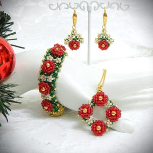 May include: A beaded jewelry set featuring a bracelet, earrings, and a necklace. The set includes red flower-shaped beads with gold accents, green and white beads, and gold-colored metal findings. The jewelry is displayed on a white surface.