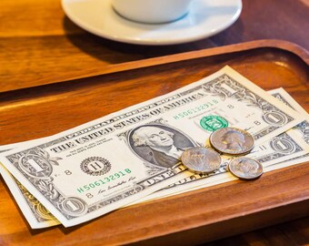 US Dollar Bills and Coins on Wooden Tray