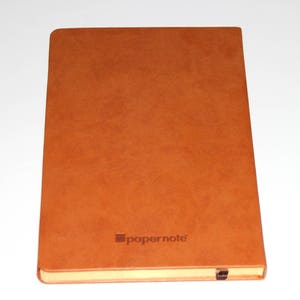 May include: A brown leather-bound notebook with the word "papernote" embossed on the front cover.