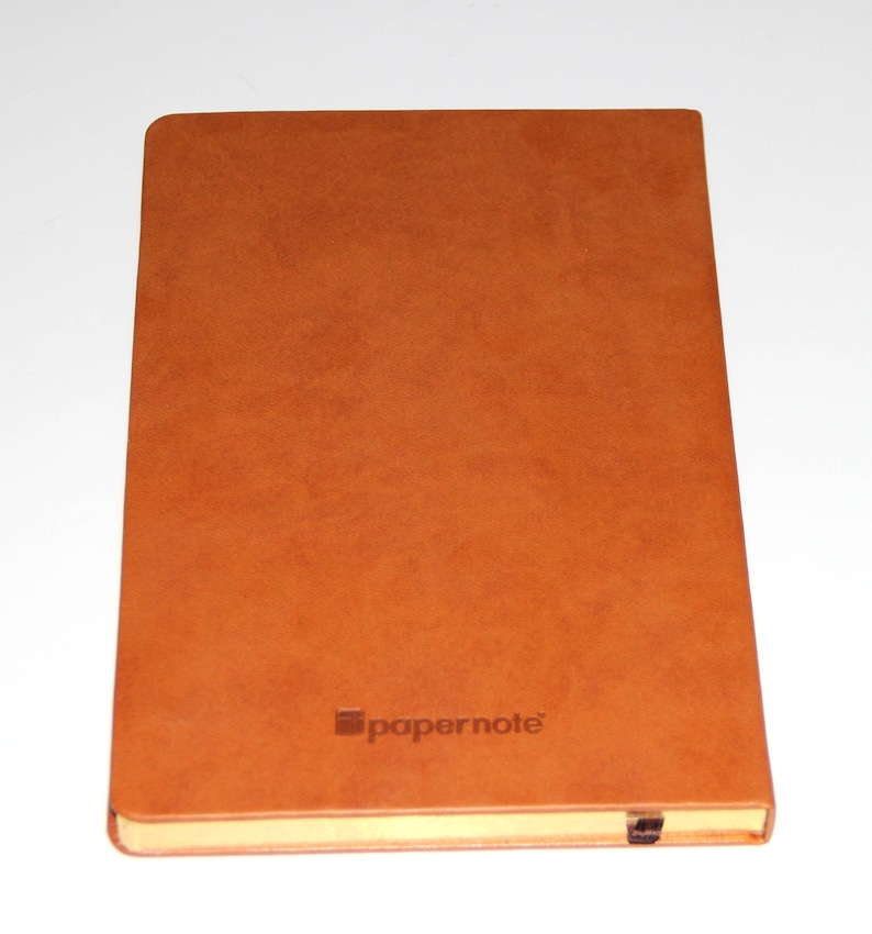 May include: A brown leather-bound notebook with the word "papernote" embossed on the front cover.
