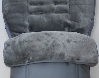 May include: Gray stroller liner with a soft, plush lining. The liner has a zipper closure and is quilted for added warmth.