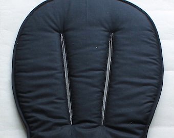 May include: Black padded seat cushion with three seams down the center. The cushion is designed to fit a high chair or booster seat.