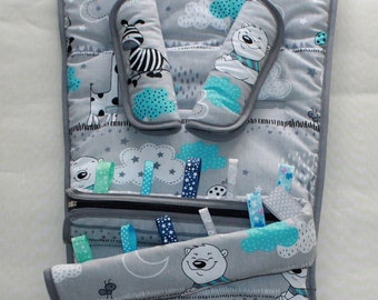 May include: A grey and white baby seat cushion with a zipped pocket. The cushion features a playful design with clouds, stars, and animals such as zebras and polar bears. The cushion has two removable armrests with a blue and white pattern.
