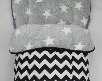 May include: A gray and white stroller insert with a star pattern on the top section and a black and white chevron pattern on the bottom. The insert is designed to provide comfort and support for infants.