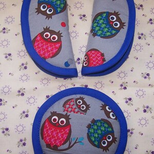 May include: Two semi-circular fabric pads and one circular fabric pad, all featuring a gray background with a repeating pattern of brown owls wearing red or green plaid vests, finished with a solid blue fabric trim along the curved edges.