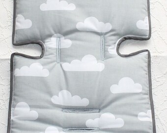 May include: Gray and white baby stroller seat cushion with a cloud pattern. The cushion has a gray border and is made of soft fabric.