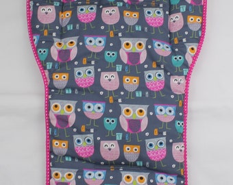 May include: A gray and pink high chair cushion with a pattern of owls. The cushion has a pink border with white polka dots.