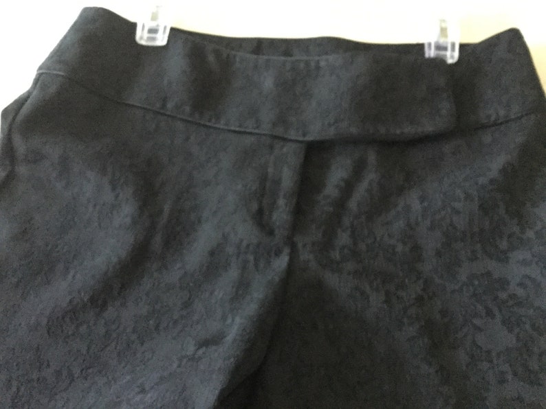 Puede incluir: Pantal&oacute;n negro con estampado floral. El pantal&oacute;n tiene una cintura con trabillas.