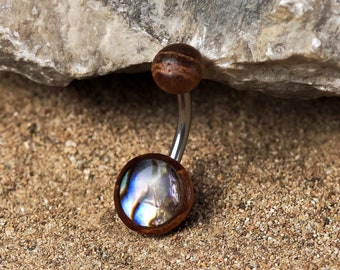 May include: A silver belly button ring with a brown wooden top and a blue and iridescent abalone shell bottom.