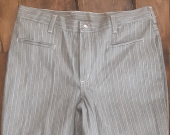 May include: Gray striped pants with a white stripe pattern. The pants have a zipper fly and button closure.