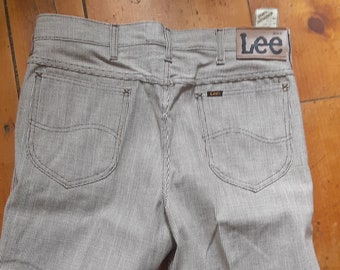 May include: Back view of Lee striped pants. The pants are a light brown color with vertical white stripes. The Lee logo is visible on a brown leather patch. The pants have two back pockets.