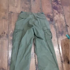 May include: A pair of green cargo pants with two large pockets on each leg.