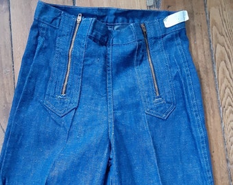 May include: A pair of blue denim pants with two gold zippers down the front.