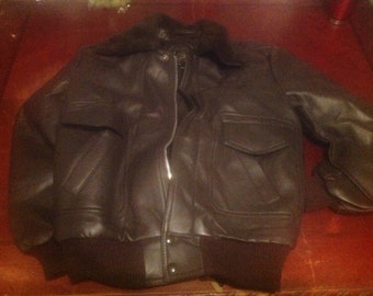 May include: A brown leather bomber jacket with a zipper closure and a fur-lined collar.