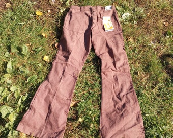 Könnte beinhalten: Eine braune, weite Hose mit Knopfleiste und einem kleinen Etikett mit der Aufschrift "Big Tower" am rechten Bein.