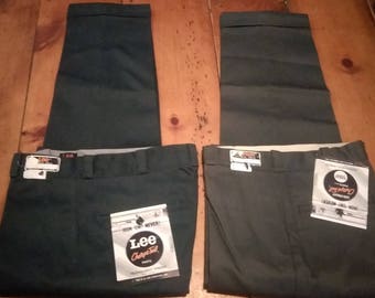 Può includere: Due paia di pantaloni da lavoro verde scuro con cintura bianca e etichetta Lee Cooper. I pantaloni hanno gamba dritta e sono realizzati in un tessuto resistente.