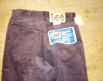 May include: Brown corduroy pants with a Lee label on the back pocket. The label has the text "Lee" and "Regular Fit" printed on it.