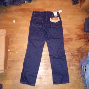 May include: A pair of dark blue denim jeans with a red and white label that says "Prewashed" and "Regular Fit".