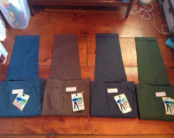 Puede incluir: Cinco pares de pantalones para hombre en diferentes colores, incluyendo azul, marrón, gris y verde. Cada par tiene una etiqueta adjunta con el texto "Mr. Big & Tall" y un gráfico de un hombre con un traje.