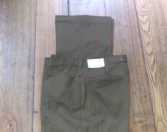 Può includere: Un paio di pantaloni a righe marroni e arancioni con un'etichetta bianca.