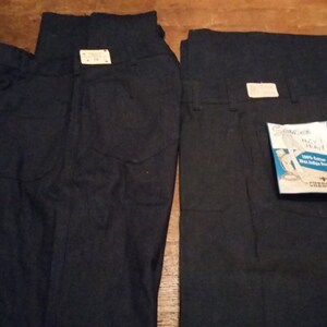 Può includere: Due paia di jeans in denim blu scuro con un'etichetta bianca che dice "Cherokee Work Wear Navy Jean 100% Cotton Washed Indigo Denim".