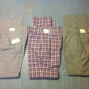 May include: Three pairs of plaid pants in different color combinations. The pants are all made of a woven fabric and have a classic, tailored look.