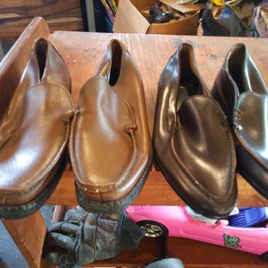 May include: Three pairs of leather slip-on shoes. Two pairs are brown and one pair is dark brown.