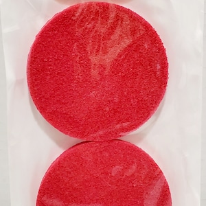 May include: Two red cosmetic sponges in a clear plastic bag. The bag has a white label with the text "COSMETIC SPONGE Professional Quality".