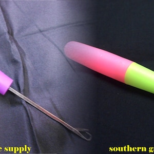 Peut inclure: Deux enfile-aiguilles à fil en plastique avec des pointes métalliques. Le premier est violet et le second est rose et vert.