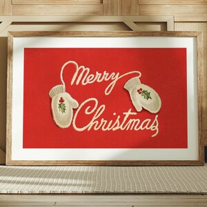 May include: Framed art print with a red background and the words "Merry Christmas" in cursive script. Two white mittens with holly accents are on the red background. The art is in a wooden frame.