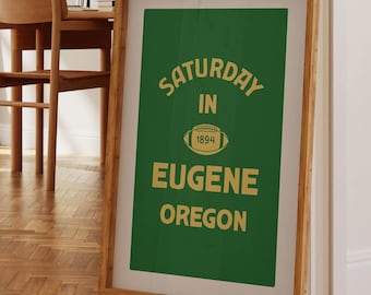 May include: A framed green poster with gold text that reads "SATURDAY IN EUGENE OREGON" with a football graphic and the year 1994.