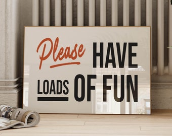 May include: A white framed poster with the text "Please Have Loads of Fun" in black and orange lettering.