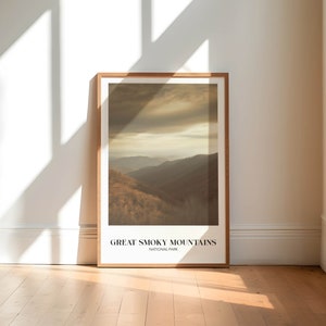 Op de afbeelding: Een ingelijste poster met een foto van een bergketen met een bewolkte lucht. De tekst "GREAT SMOKY MOUNTAINS NATIONAL PARK" staat onderaan de poster gedrukt.