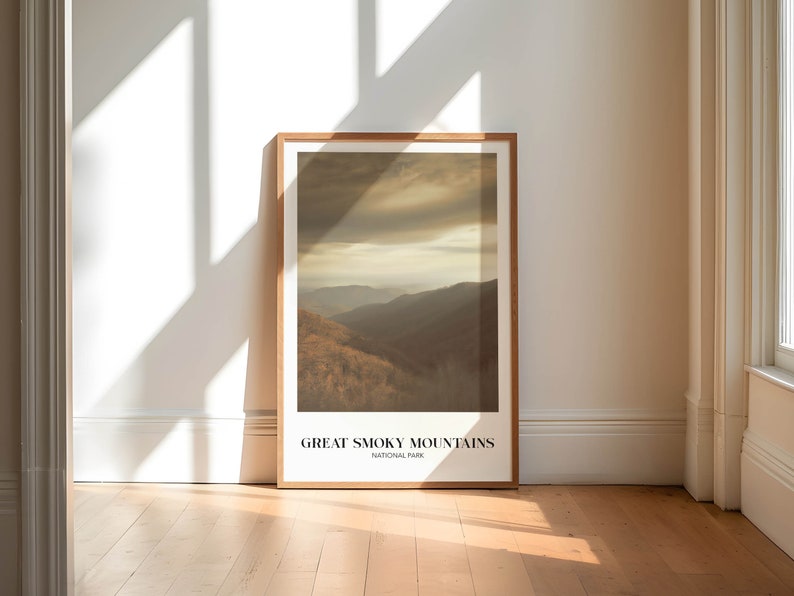 Op de afbeelding: Een ingelijste poster met een foto van een bergketen met een bewolkte lucht. De tekst "GREAT SMOKY MOUNTAINS NATIONAL PARK" staat onderaan de poster gedrukt.