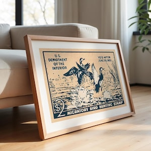 Pode incluir: Um cartaz de estilo vintage para um selo de ca&ccedil;a a aves migrat&oacute;rias. O cartaz apresenta uma ilustra&ccedil;&atilde;o azul e branca de tr&ecirc;s patos em voo sobre um corpo de &aacute;gua. O texto no cartaz diz "U.S. Department of the Interior", "Void After June 30, 1952", "$2", e "Migratory Bird Hunting Stamp".