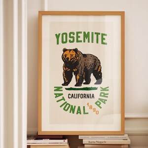 Pu&ograve; includere: Una stampa incorniciata con un design vintage che presenta un orso bruno e il testo "Yosemite National Park, California 1890".