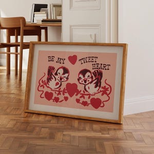 May include: A framed print with a pink background and two cartoon birds on a branch. The birds are holding hearts and the text "Be My Tweet Heart" is written above them.