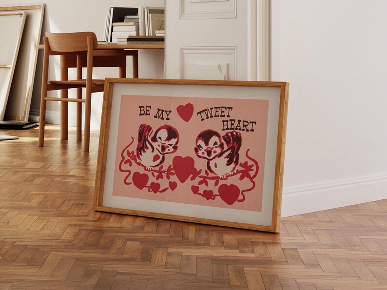 May include: A framed print with a pink background and two cartoon birds on a branch. The birds are holding hearts and the text "Be My Tweet Heart" is written above them.