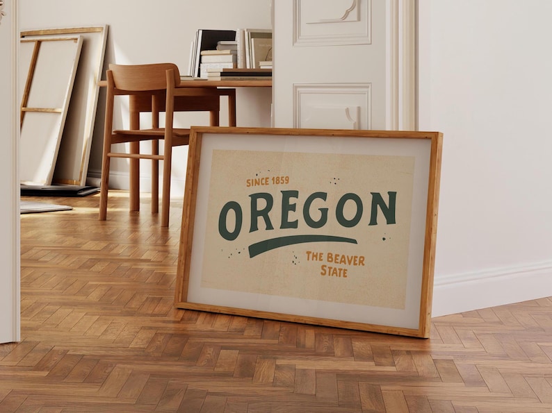 May include: A framed print with a beige background and a green and orange graphic that says "Oregon, The Beaver State, Since 1859".
